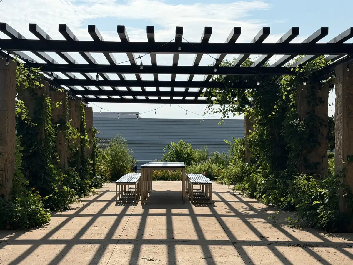 Shaded pergola and gathering tables at the Lynn Community Garden at Expand